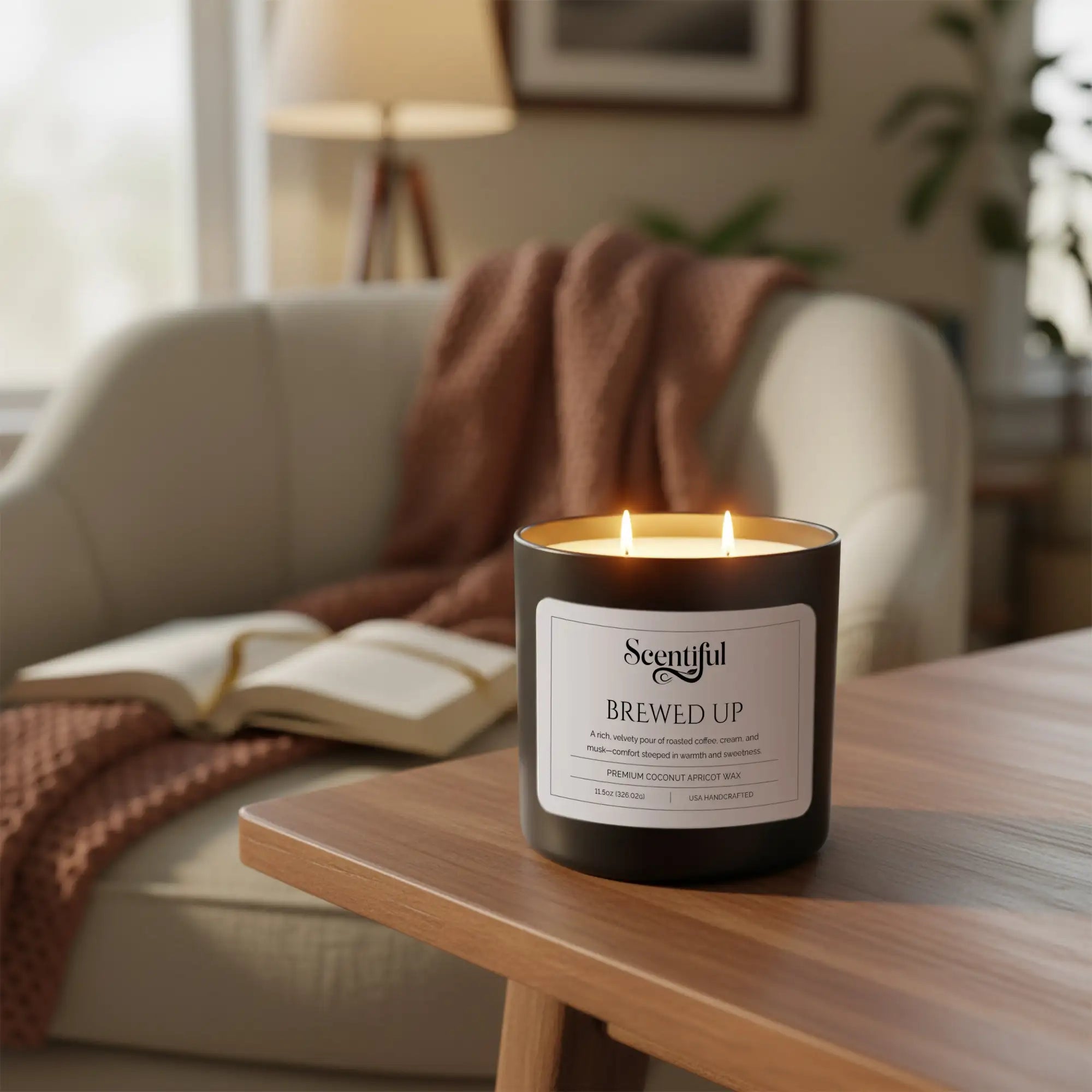 A black cylindrical candle with two lit wicks, labeled ’scentful brewed up’ and made of premium coconut apricot wax.